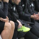 Auswechselspieler sitzen auf der Ersatzbank.