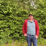 Lars Kuhnt steht vor einem Busch.