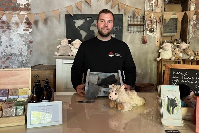 Enno Giese von Vivampos Alpaka hinter der Verkaufsteheke des Hofladens