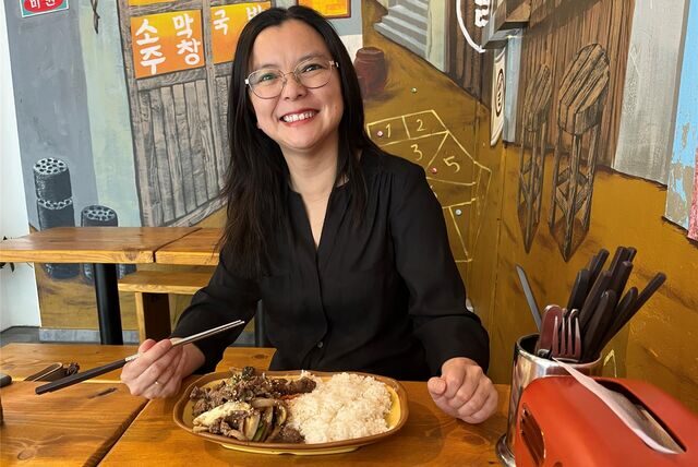 Kulinarischer Ausflug in die Geburtsstadt: Melanie im „Sonamu“ , das Bild im Hintergrund zeigt eine Straßenszene aus Koreas Hauptstadt Seoul.