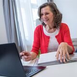 Eine Frau sitzt vor ihrem Laptop.