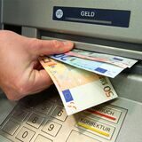 Ein Kunde zieht am Geldautomaten einer Bank Geldscheine. (Symbolbild)