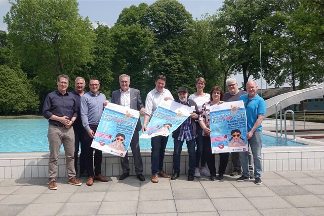 Das Gruppenfoto zeigt die Organisatoren und Sponsoren des Freibadfests mit Plakaten.