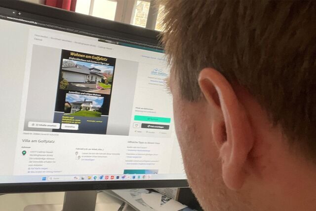 Ein Mann sieht sich auf dem Computer eine Immobilienanzeige an.