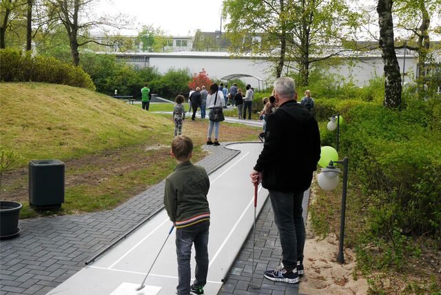 Menschen spielen Minigolf.