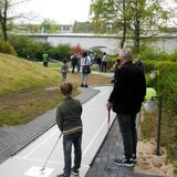 Menschen spielen Minigolf.