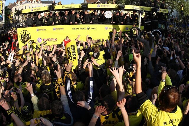 Fans jubeln bei der Meisterfeier des BVB der Mannschaft auf einem Lkw zu.