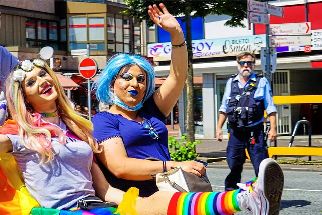 Zwei Teilnehmer des Christopher Street Days winken in die Kamera.