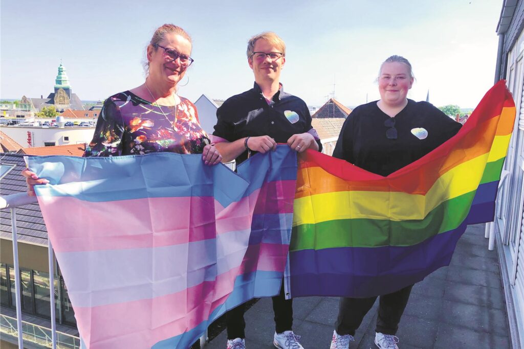 Rita Nowak, Daniel Petzoldt und Irina Oberpichler vom Verein Vestischer Christopher Street Day halten eine Regenbogenflagge in der Hand. Rita Nowak, Daniel Petzoldt und Irina Oberpichler vom Verein Vestischer Christopher Street Day halten eine Regenbogenflagge in der Hand.
