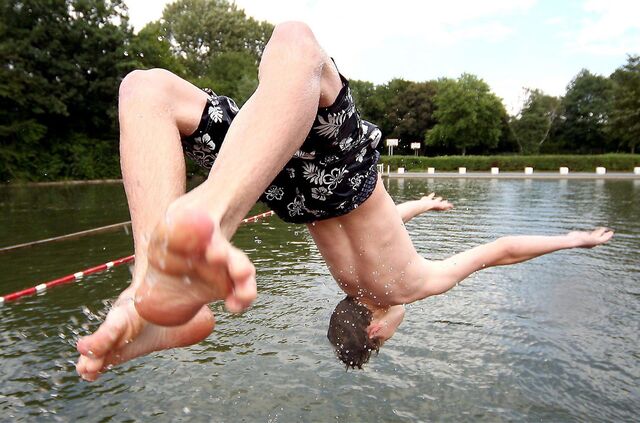 Ein Junge springt kopfüber ins Naturfreibad Suderwich in Recklinghausen.