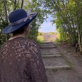 Eine Frau mit Sonnenhut schaut hoch in Richtung Halde Schwerin.