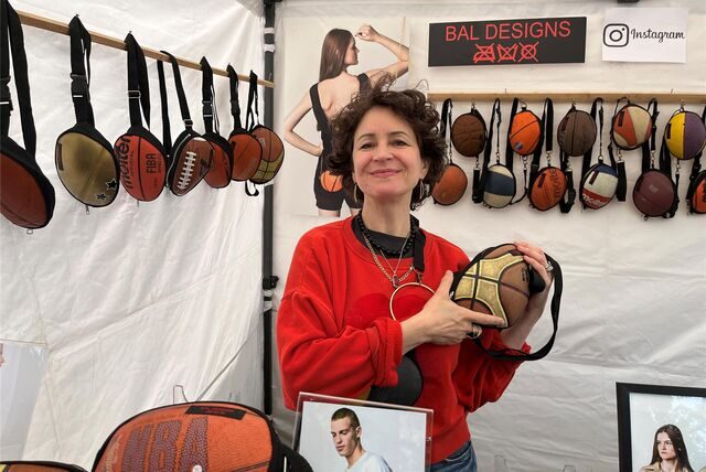 Rita Balta steht an ihrem Stand und hält einer ihrer Taschen aus einem alten Basketball in die Kamera.