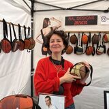 Rita Balta steht an ihrem Stand und hält einer ihrer Taschen aus einem alten Basketball in die Kamera.