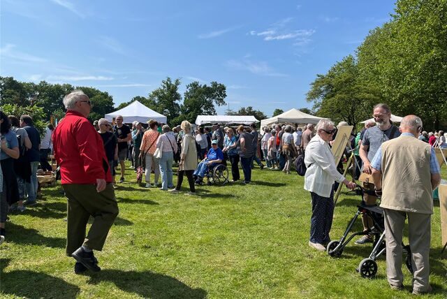 Menschen schlendern über den Kunstmarkt im Schlosspark.