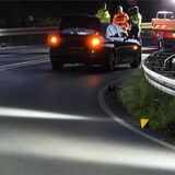 Ein Auto steht auf einer Autobahnauffahrt. Im Hintergrund stehen Polizei und Feuerwehr.
