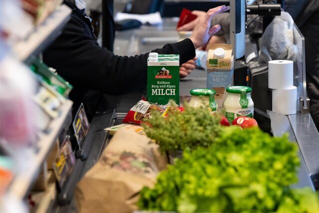 Lebensmittel liegen in einem Supermarkt an der Kasse auf dem Band.