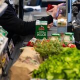 Lebensmittel liegen in einem Supermarkt an der Kasse auf dem Band.