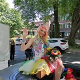 Eine Teilnehmerin des CSD in Recklinghausen sitzt in einem Cabrio, der um den Wall fährt, und winkt in die Kamera