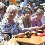 Marktbesucher essen Pommes.