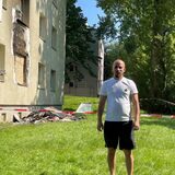 Ibrahim Ghaddar steht auf der Wiese vor dem Haus, in dem er wohnt und in dem es am Sonntag brannte.