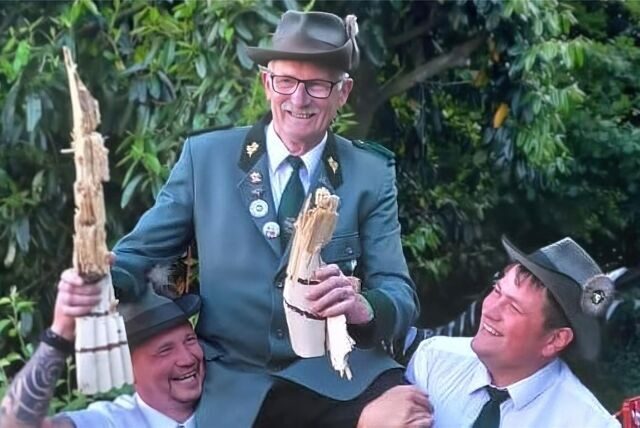 Zwei Schützenbrüder tragen Hermann-Josef Dickhöfer aus Waltrop auf ihren Schultern. Er hält die Überreste des von ihm abgeschossenen Schützenvogels in den Händen.