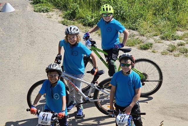 Vier Kinder in blauen Trikots stehen an ihren Mountainbikes bei der NRW-MTB-Schulsportmeisterschaft. Sie gehören zur Mountainbike-AG der Ewaldschule in Oer-Erkenschwick.