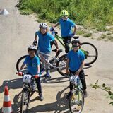Vier Kinder in blauen Trikots stehen an ihren Mountainbikes bei der NRW-MTB-Schulsportmeisterschaft. Sie gehören zur Mountainbike-AG der Ewaldschule in Oer-Erkenschwick.