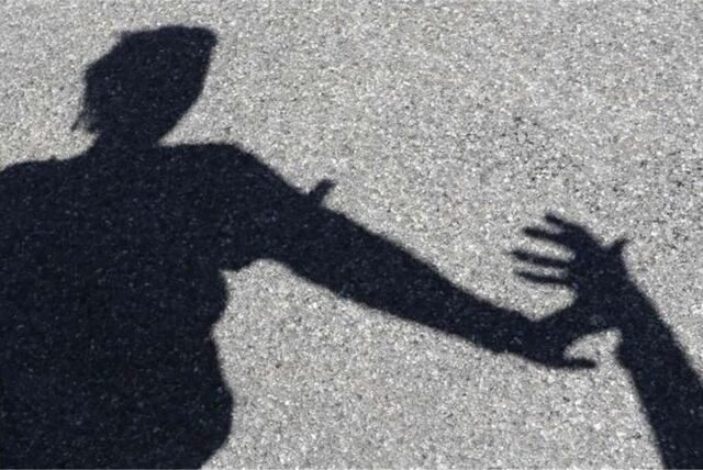 Schattenspiel zeigt eine Hand, die eine andere abwehrt