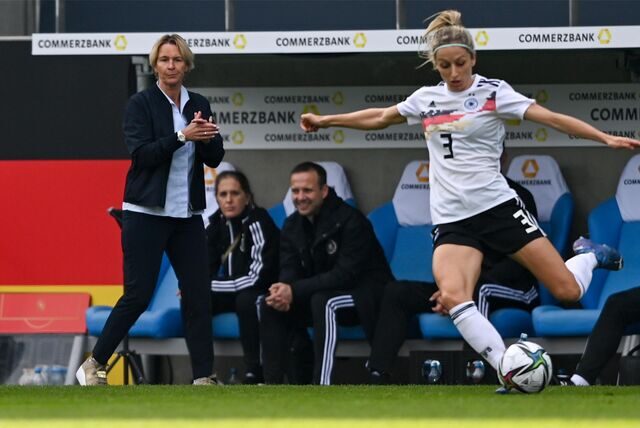Fußball-Bundestrainerin Martina Voss-Tecklenburg (l) reagiert an der Seitenlinie hinter Deutschlands Kathrin Hendrich