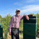 Helmuth Kessen steht zwischen zwei Bienenstöcken auf der Halde Hoheward.
