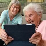 Zwei Rentnerinnen beschäftigen sich in einem Seniorenheim mit ihren Tablets.
