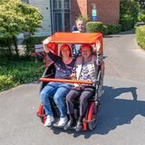 Iris Foggia, Leiterin des Sozialdienstes im Ludgerushaus und Luzie Wagner (86) genießen die Fahrt mit der Fahrrad-Rikscha.  Heinrich Mertenskötter (70) tritt in die Pedale.