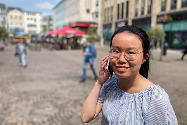 Die Redakteurin telefoniert auf dem Marktplatz.