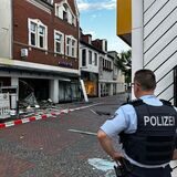 Ein Polizist steht vor einem zerstörten Bankgebäude