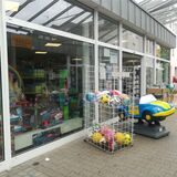 Ein Korb mit Bällen und ein Kinderauto stehen vor einem Spiel- und Schreibwarengeschäft in Haltern.