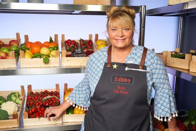 Sabine Gadalla steht im Studio von „The Taste“, im Hintergrund gefüllte Obst- und Gemüsekörbe.