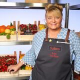 Sabine Gadalla steht im Studio von „The Taste“, im Hintergrund gefüllte Obst- und Gemüsekörbe.