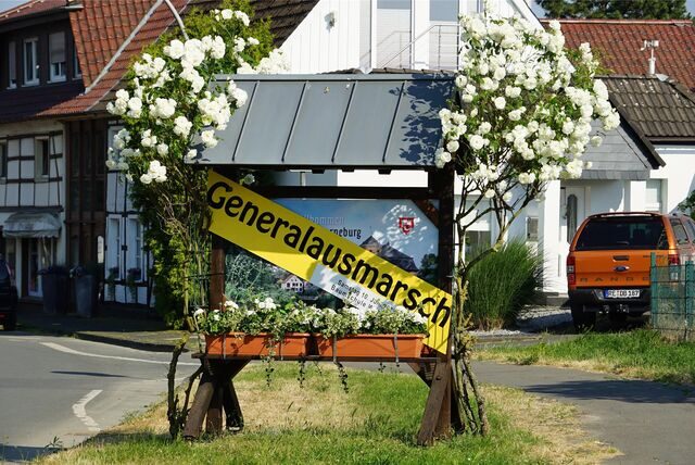 Ein Ortseingangsschild mit einer gelben Banderole, auf der das Wort Generalausmarsch geschrieben steht.