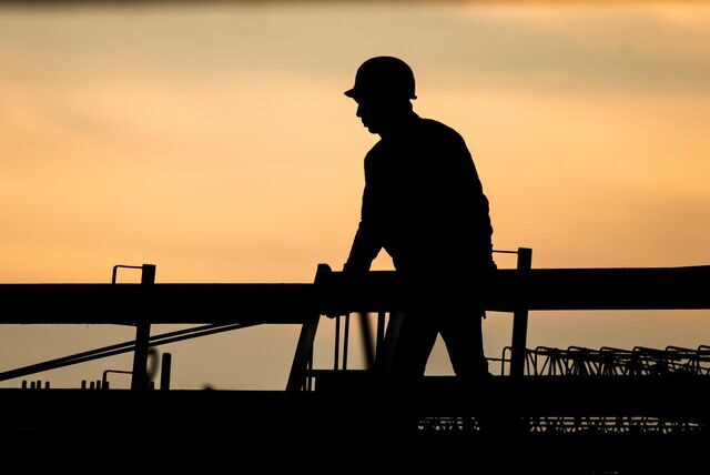 Die Silhouette eines Bauarbeiters im Sonnenuntergang