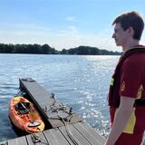 DLRG-Mitglied Johannes Wintz steht auf dem Einsatzsteg im Seebad, an dem nur noch ein Ruderboot liegt.