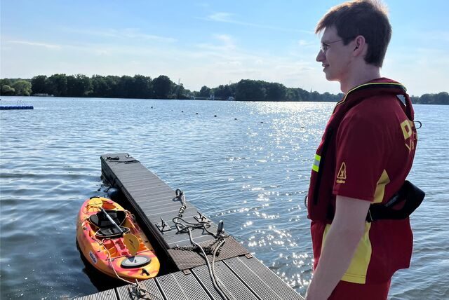 DLRG-Mitglied Johannes Wintz steht auf dem Einsatzsteg im Seebad, an dem nur noch ein Ruderboot liegt.