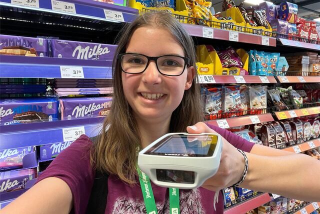 Katharina Göke mit dem Handscanner vor dem Süßigkeiten-Regal im Rewe.
