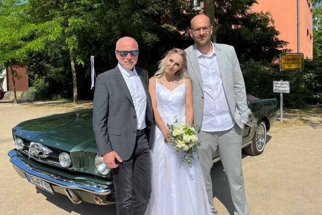 Fred Toplak, Katharina und Marco Schwerma vor einem Mustang Cabrio.