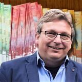 Schweizer Franken auf einem Tisch. Rechts: Karsten Meyer