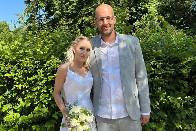 Katharina und Marco Schwerma vor einer Hecke.