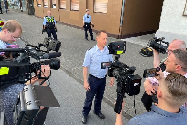 Polizeisprecher Andreas Lesch am Donnerstagabend vor den Kameras verschiedener Reporterteams, hinter ihm die Polizeikette am Tatort: Die Polizei ermittelt nun mit der Staatsanwaltschaft in einer Mordkommission.