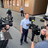 Polizeisprecher Andreas Lesch am Donnerstagabend vor den Kameras verschiedener Reporterteams, hinter ihm die Polizeikette am Tatort: Die Polizei ermittelt nun mit der Staatsanwaltschaft in einer Mordkommission.