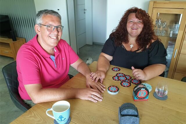 Stefanie und Michael Grubinski aus Recklinghausen sitzen am Esstisch und spielen ein Gesellschaftsspiel.