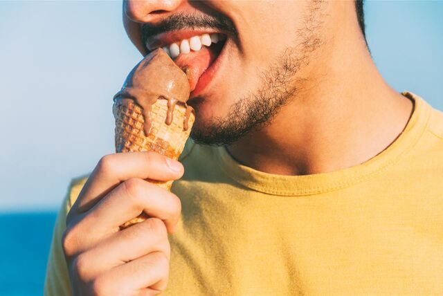 Ein Mann leckt an einer Eiskugel
