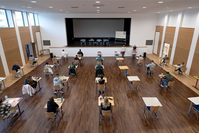 Schülerinnen und Schüler eines Gymnasiums sitzen vor Beginn ihrer schriftlichen Prüfung im Fach Geschichte an ihren Plätzen.